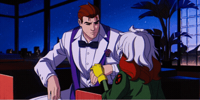 A Man In A Tuxedo Is Talking To A Girl With A X-Men Logo On Her Jacket GIF