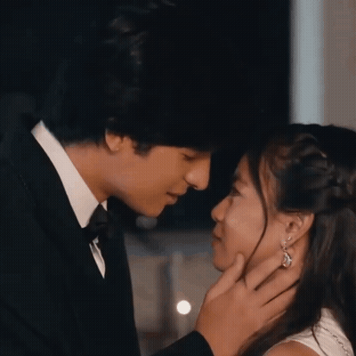 A Man In A Tuxedo Is Touching A Woman 'S Face GIF