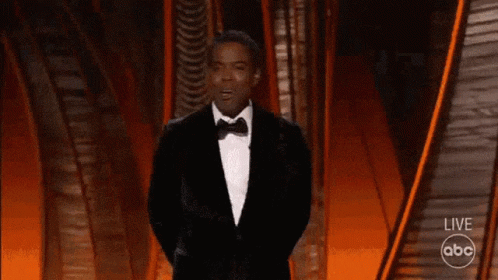 A Man In A Tuxedo Is Walking On A Stage With A Abc Logo In The Background GIF