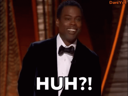 A Man In A Tuxedo Says Huh On A Stage GIF