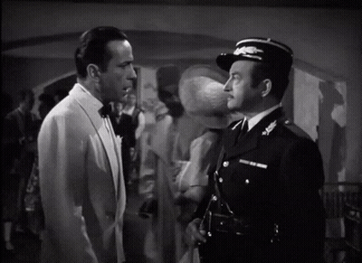A Man In A Tuxedo Stands Next To A Man In A Uniform GIF