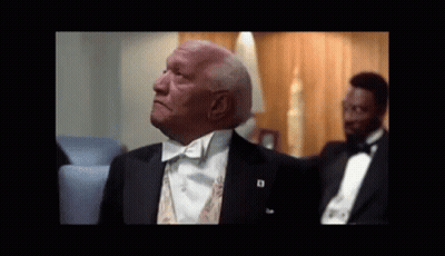 A Man In A Tuxedo With A Badge That Says D On It GIF