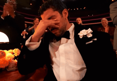 A Man In A Tuxedo With A White Flower In His Lapel Is Crying GIF