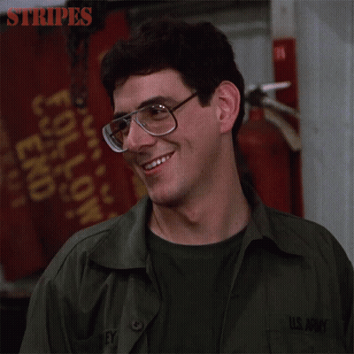 A Man In A U.s. Army Uniform Is Smiling And Wearing Glasses GIF
