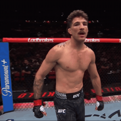 A Man In A Ufc Belt Stands In A Boxing Ring GIF