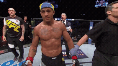 A Man In A Ufc Shirt Is Standing In A Boxing Ring GIF