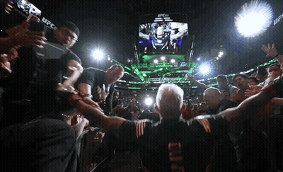 A Man In A Ufc Shirt Stands In Front Of A Crowd Of People GIF