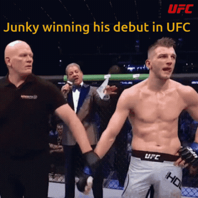 A Man In A Ufc Shorts Holds The Hand Of Another Man GIF