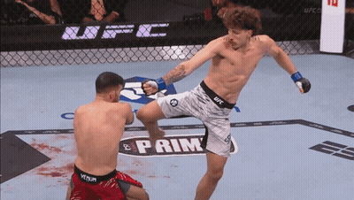 A Man In A Ufc Shorts Kicking Another Man In Red Shorts GIF