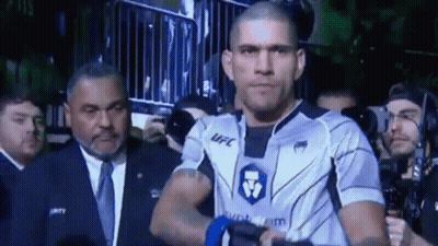 A Man In A Ufc Uniform Is Walking Through A Crowd . GIF