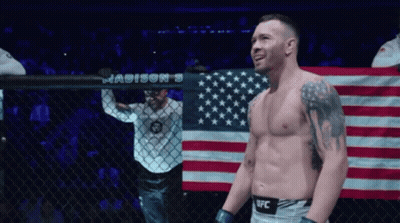 A Man In A Ufc Uniform Stands In Front Of A Madison 'S Banner GIF