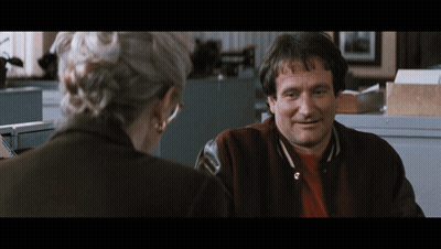 A Man In A Varsity Jacket Is Smiling While Talking To A Woman GIF