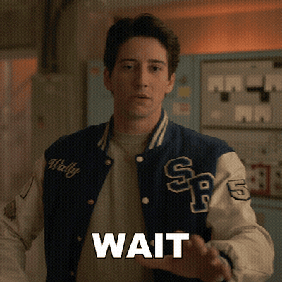 A Man In A Varsity Jacket With The Word Wait On It GIF
