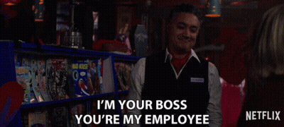 A Man In A Vest Says " I 'M Your Boss You 'Re My Employee " In Front Of A Shelf Of Magazines GIF