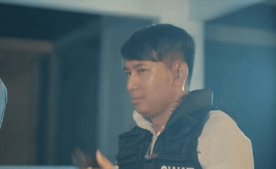 A Man In A Vest With The Word Squad On It Holds A Gun GIF