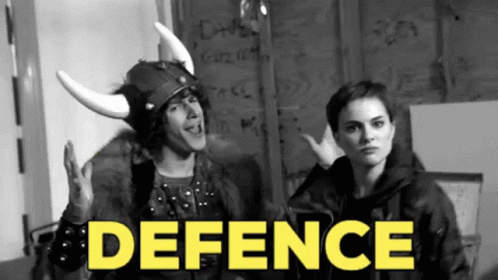 A Man In A Viking Helmet Stands Next To A Woman With The Word Defence In Yellow GIF