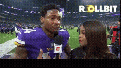 A Man In A Vikings Jersey Is Talking Into A Microphone GIF