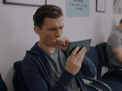 A Man In A Waiting Room Looks At His Phone GIF