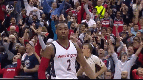 A Man In A Washington Jersey Stands In Front Of A Crowd Of Fans GIF