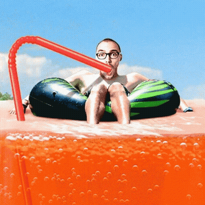 A Man In A Watermelon Float Drinks Through A Straw GIF