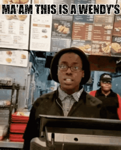 A Man In A Wendy 'S Restaurant Behind A Counter GIF