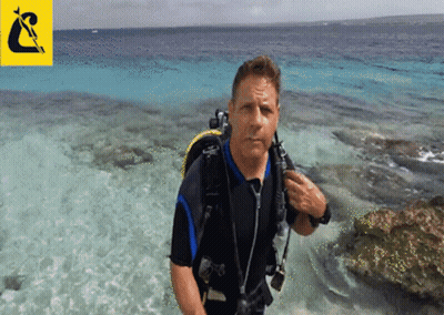 A Man In A Wetsuit Is Standing In The Water GIF