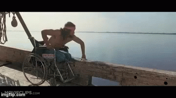 A Man In A Wheelchair Is Standing On A Dock Near The Water GIF
