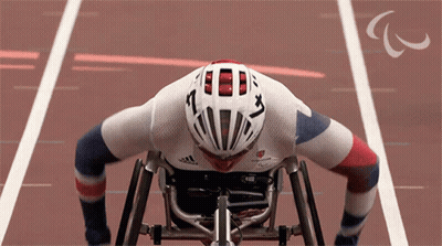 A Man In A Wheelchair Wearing A Helmet That Says ' A ' On It GIF