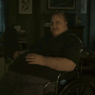 A Man In A Wheelchair With A Blue Sticker On The Wheel That Says ' Adaptive ' GIF