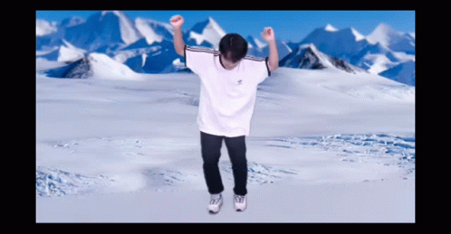 A Man In A White Adidas Shirt Is Dancing In Front Of Snowy Mountains GIF