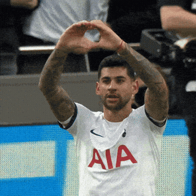 A Man In A White Aia Shirt Makes A Heart Shape With His Hands GIF