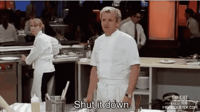 A Man In A White Chef 'S Coat Is Standing In A Kitchen . GIF