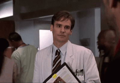 A Man In A White Coat And Tie Holds A Clipboard With A Yellow Sticker That Says ' A ' On It GIF