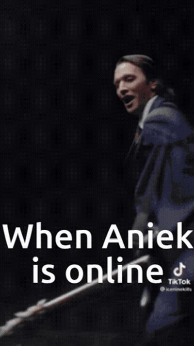 A Man In A White Coat And Tie Is Standing In Front Of A Wall With The Words `` When Anick Is Online '' . GIF