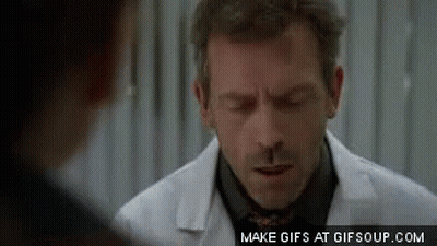 A Man In A White Coat And Tie Is Talking To Another Man In A Black Shirt . GIF