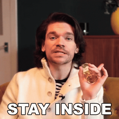 A Man In A White Coat Is Holding A Glass With The Words Stay Inside Above Him GIF