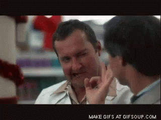 A Man In A White Coat Is Talking To Another Man In A Store GIF