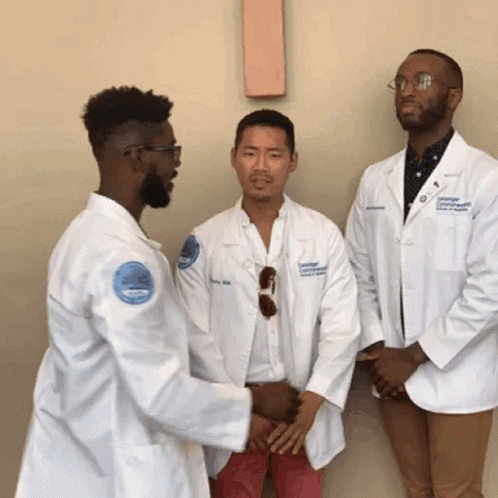 A Man In A White Coat With A Badge That Says ' University Of Connecticut ' On It GIF