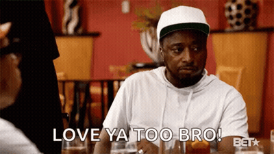 A Man In A White Hat Is Sitting At A Table With A Woman And Says Love Ya Too Bro . GIF