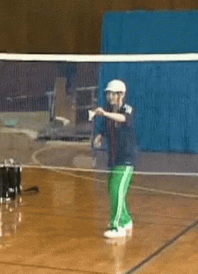 A Man In A White Hat Is Standing In Front Of A Volleyball Net GIF
