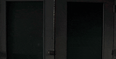 A Man In A White Hoodie Is Looking Out A Window GIF