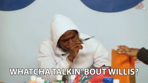 a man in a white hoodie is sitting at a table and says whatcha talkin ' bout willis