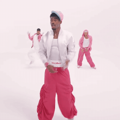 A Man In A White Jacket And Pink Pants Is Dancing With Two Other People GIF