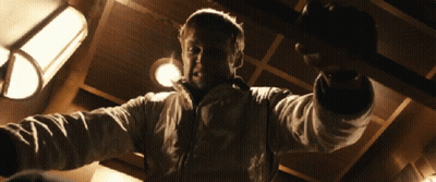 A Man In A White Jacket Is Pointing At The Camera GIF
