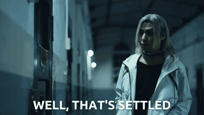 A Man In A White Jacket Is Standing In A Dark Hallway With The Words Well That 'S Settled Below Him GIF