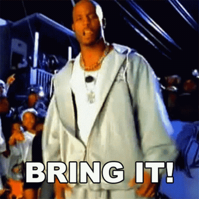 A Man In A White Jacket Is Standing In Front Of A Crowd With The Words Bring It Written On The Screen GIF