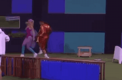 A Man In A White Jacket Is Standing Next To A Woman In A Pink Swimsuit . GIF