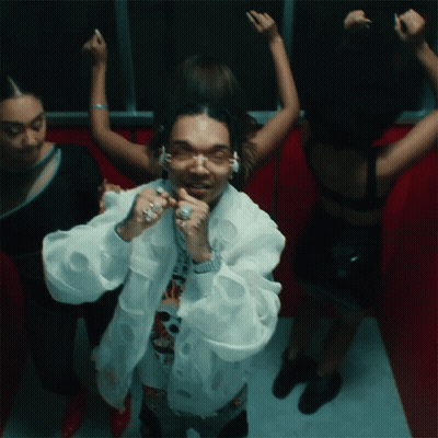 A Man In A White Jacket Is Surrounded By Women In Black Dresses GIF