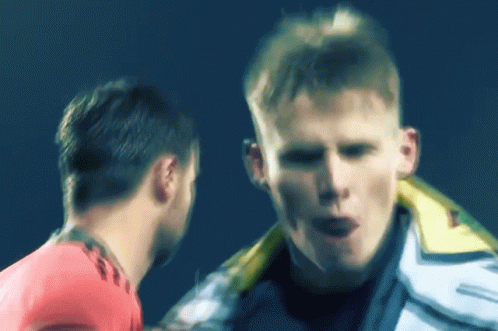 A Man In A White Jacket Is Talking To Another Man In A Pink Shirt GIF