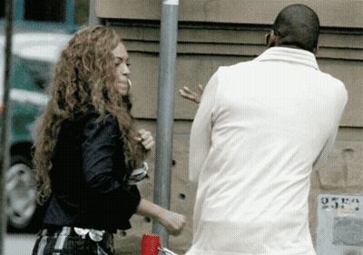 A Man In A White Jacket Stands Next To A Woman In A Black Jacket GIF
